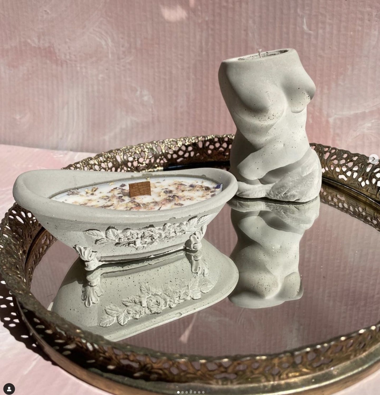 Sculptural candles, one of a luxurious clawfoot tub, one of a naked woman, on a mirrored tray, created by candlecore
