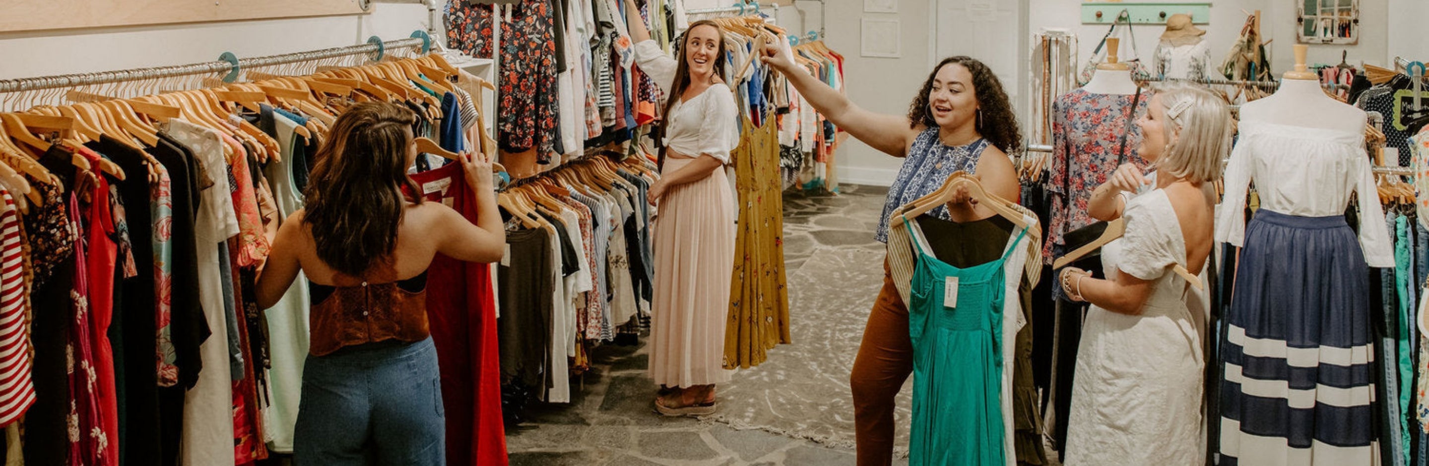 Darling x Dashing team holding up pieces of clothing and talking on the shop floor