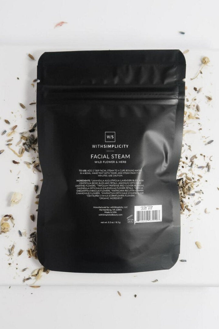 Overhead of Withsimplicity's facial steam package surrounded by natural ingredients, sold at Darling x Dashing