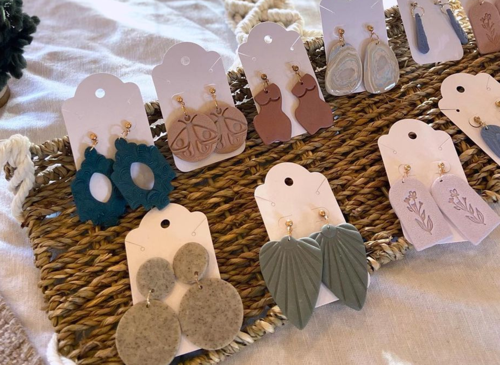 Selection of dangly clay earrings including leaves and floral prints, made by Baewolf Earrings