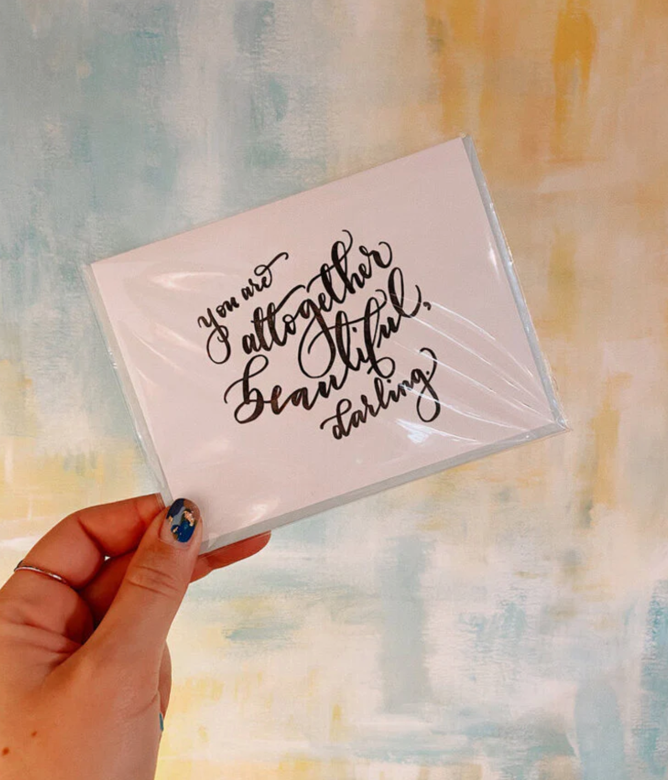 person holding a card that reads " you are all together beautiful darling" in front of textured back drop, created by dancing with ink