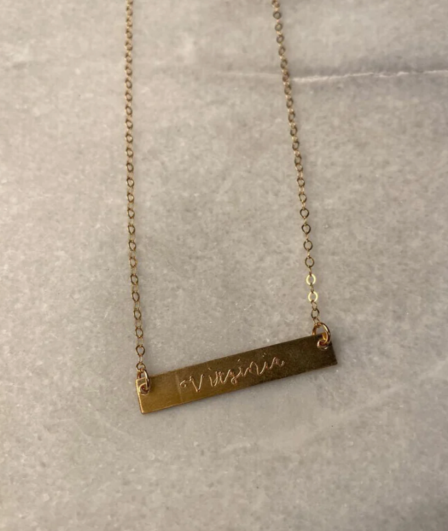 Engraved gold bar necklace that reads "Virginia" made by Onastazia