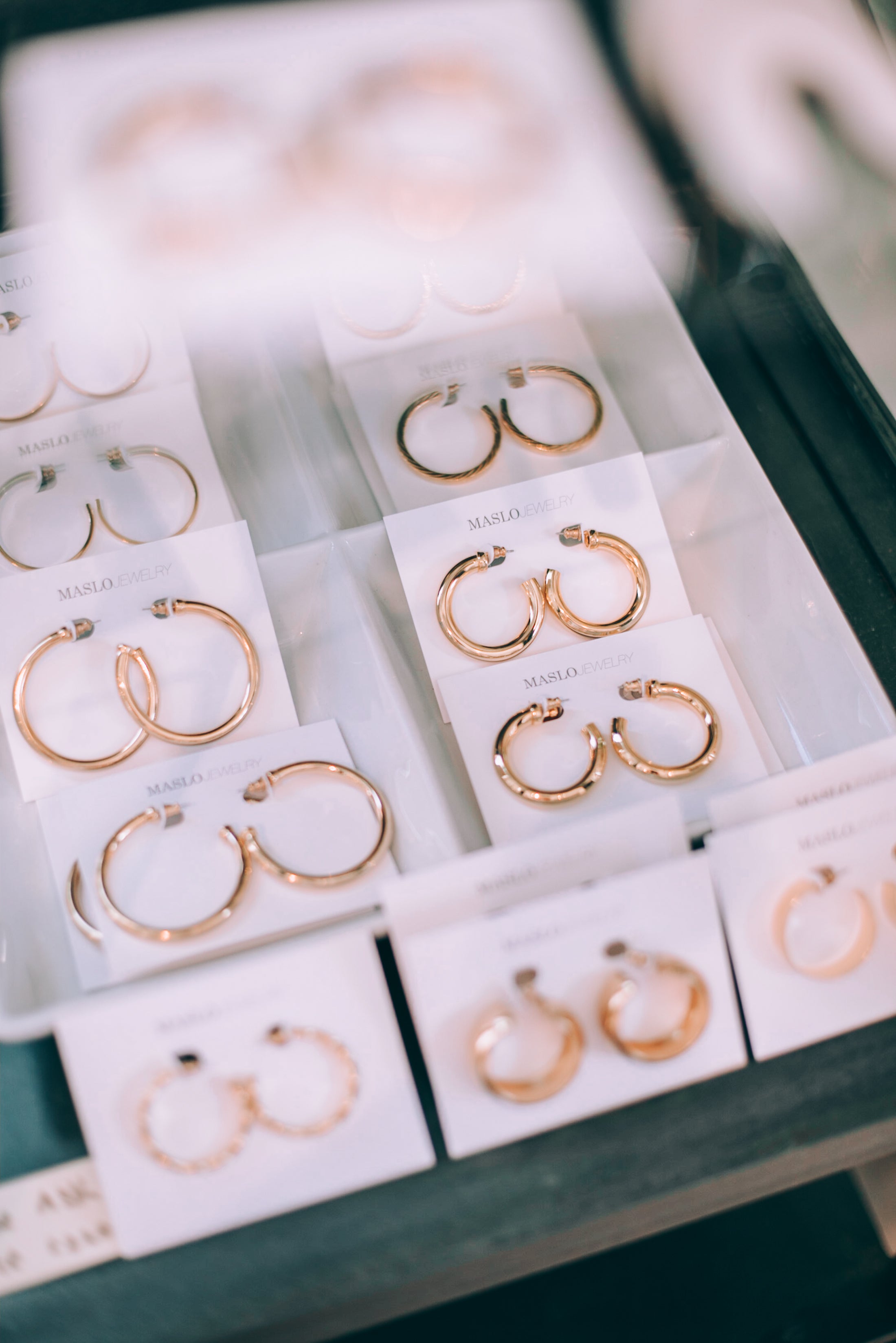Gold hoop earrings in a display case at Darling x Dashing in downtown charlottesville, Virginia